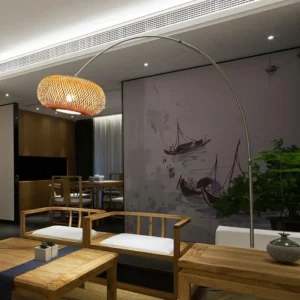 Zen Fishing Floor Lamp with an elegant curved design, illuminating a serene room with wooden furniture and a tranquil mural.