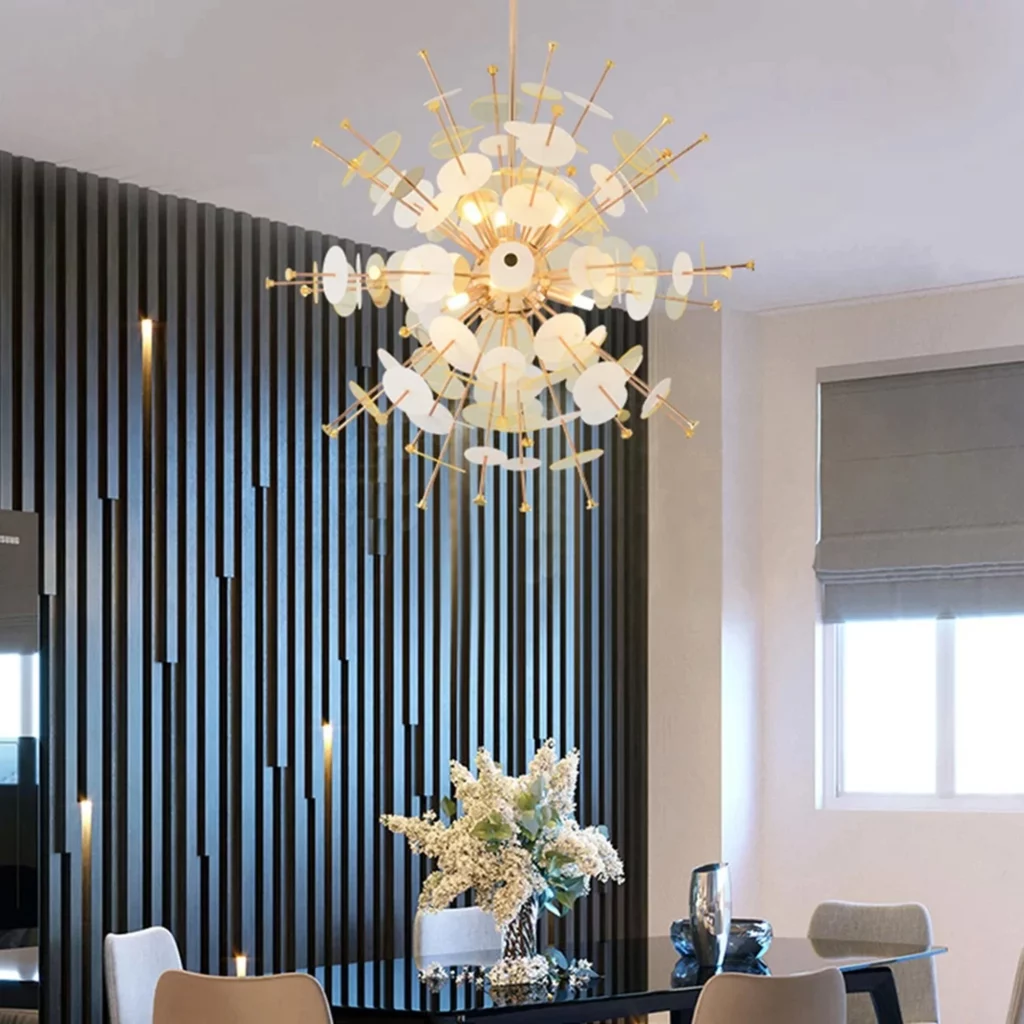 A Modern Acrylic Round Shape Sputnik Chandelier with gold spikes and white discs glows over a dining table in a contemporary room.