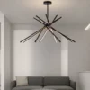 Stripe Design LED Chandelier with intersecting black and warm light bars suspended above a modern gray sofa in a minimalist living room