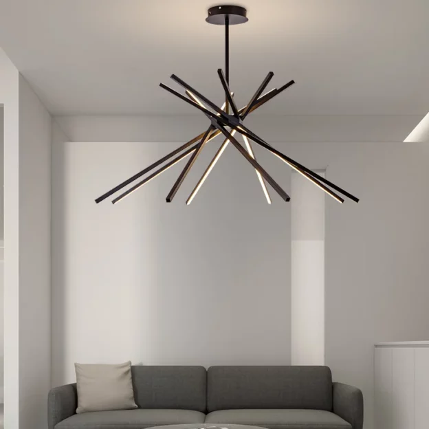 Stripe Design LED Chandelier with intersecting black and warm light bars suspended above a modern gray sofa in a minimalist living room