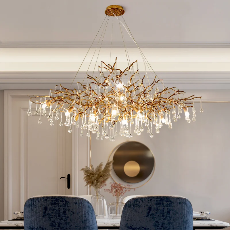 Luxury Crystal Tree Branch Chandelier with gold limbs and cascading glass droplets above an elegant dining table in a modern neutral interior