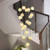 A stunning Luxury Marble Globe Staircase Chandelier with multiple glowing spheres, hanging elegantly above a staircase.