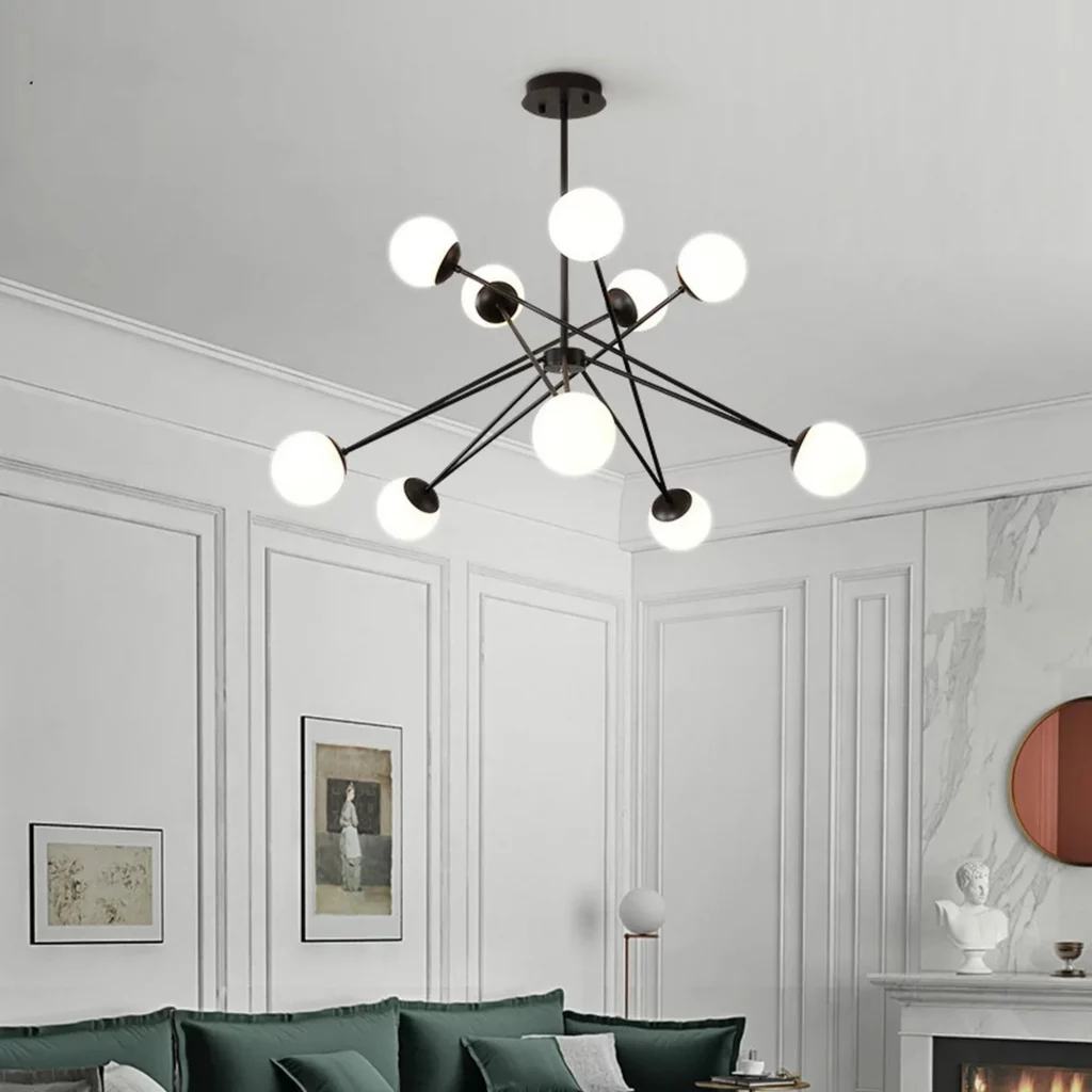 Minimalist Style Glass Ball Arm Chandelier with black metal frame and glowing globes in elegant white living room above green sofa.