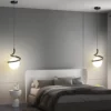 Modern bedroom with two Spiral Design Glass Ball Pendant Light fixtures hanging above upholstered bed and gray bedding