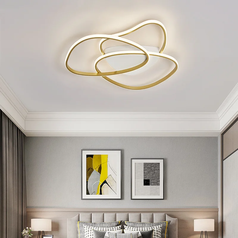 A close-up of a brushed gold Irregular Design LED Ceiling Chandelier featuring sleek, curved metallic rings and soft white light.