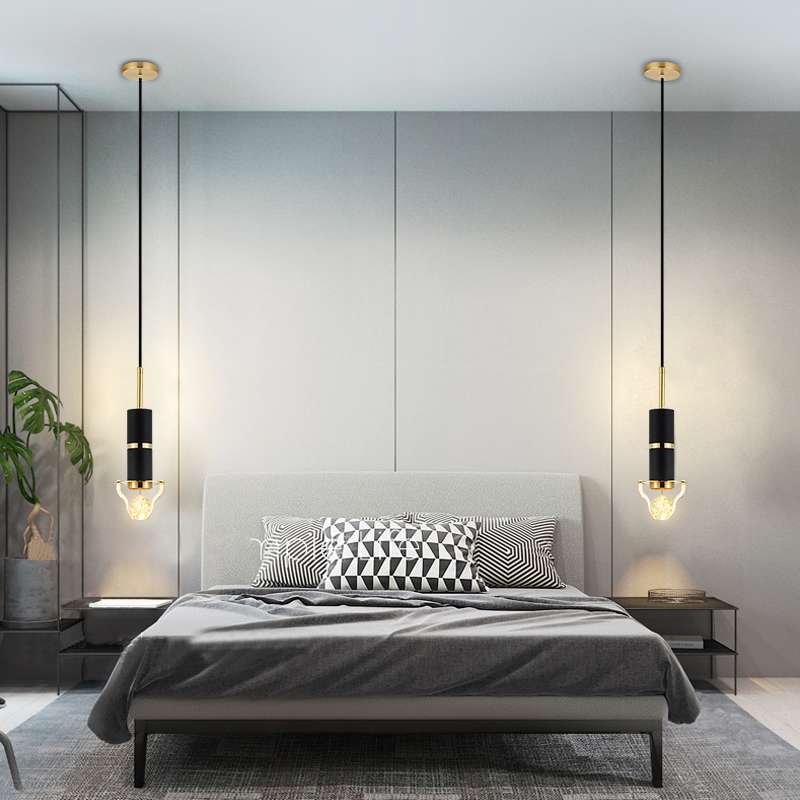 The final image showcases two Crystal Bubble Glass Elegant Pendant Lights flanking a modern bed. Each fixture features a sleek black cylindrical body with gold accents, suspended by a long cord, ending in a glowing crystal bubble glass bulb.