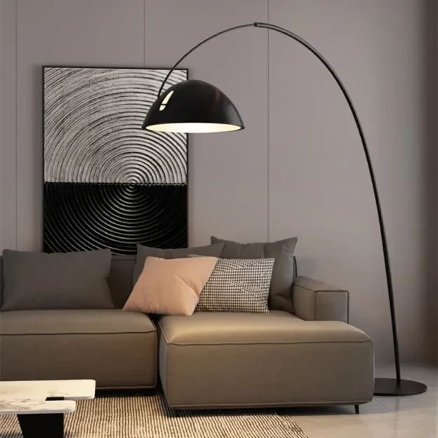 Pluma Floor Lamp over modern gray sectional sofa with black dome shade and arched arm in minimalist living room.