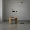 Spider Floor & Table Lamp in black with unique, curved designs, placed on a wooden table and sleek floor base.